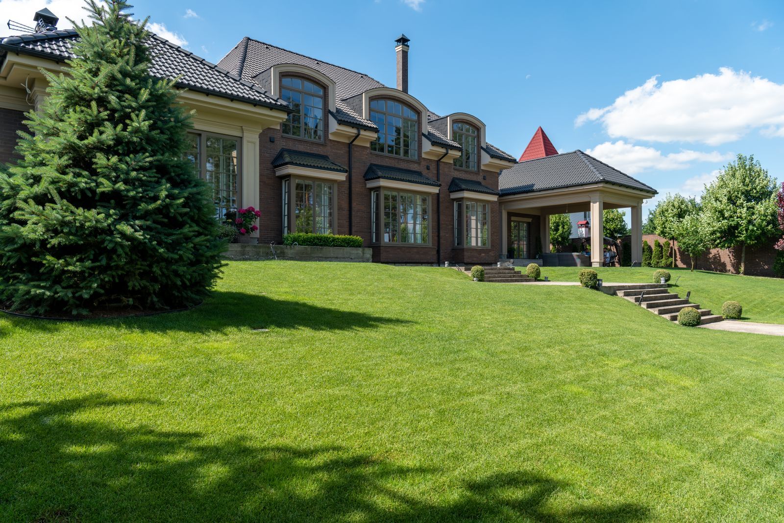 Luxury home with a manicured lawn and mature landscape beds